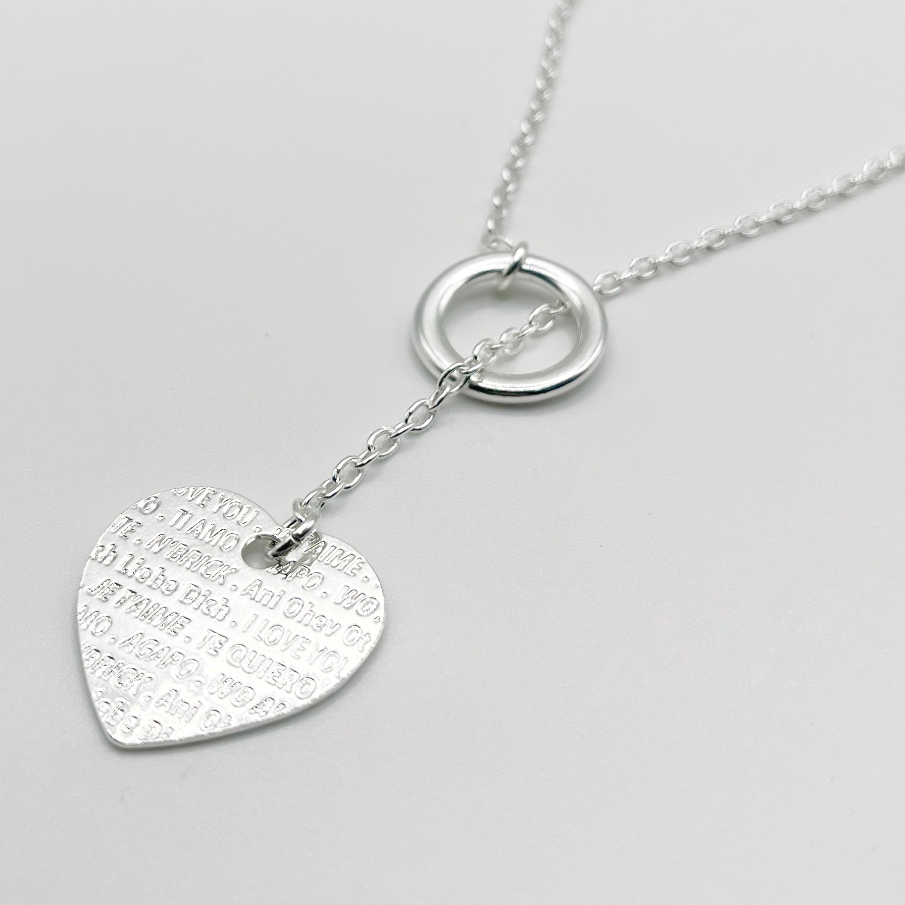 Collier sautoir sur chaîne argentée avec une pampille coeur avec inscriptions "je t'aime"
